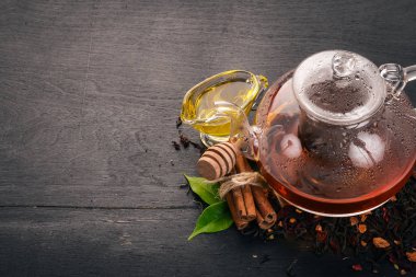 Tarçın ve bal bir ahşap zemin üzerine bir fincan çay. Sıcak bir içecek üstten görünüm. Kopya alanı.