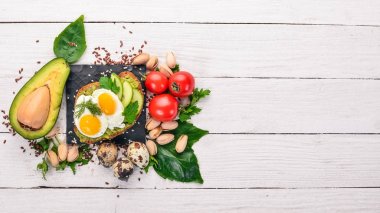 Bıldırcın yumurta, salatalık ve antep fıstığı ile avokado sandviç. Ahşap bir arka plan üzerinde. Üstten Görünüm. Metniniz için boş alan.