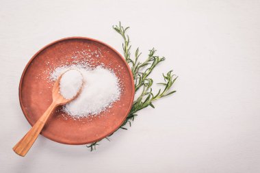 Bir plaka üzerinde bir tahta kaşık tuz. Ahşap bir arka plan üzerinde. Üstten Görünüm. Metin için boş alan.