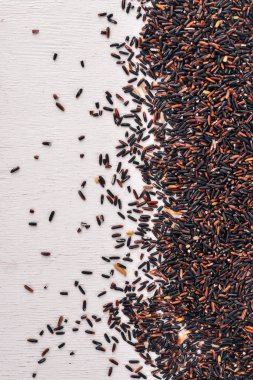 Siyah kuru pirinç. Ahşap bir arka plan üzerinde. Üstten Görünüm. Kopya alanı.