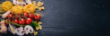 Bir makarna, erişte, makarna, tagliatelle, fettuccine, dizi Farfalle. İtalyan yemek, taze sebze ve baharat. Siyah ahşap arka plan üzerinde. Üstten Görünüm. Kopya alanı.