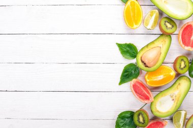 Ahşap arka plan üzerinde meyve. Avokado, limon, portakal, greyfurt ve kivi. Üstten Görünüm. Metniniz için boş alan.