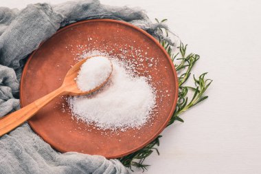 Bir plaka üzerinde bir tahta kaşık tuz. Ahşap bir arka plan üzerinde. Üstten Görünüm. Metin için boş alan.