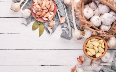 Sarımsak. Beyaz ahşap zemin üzerinde taze sarımsak kümesi. Üstten Görünüm. Kopya alanı.