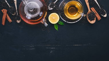 Baharat ve otlar ile cam fincan çay. Siyah ahşap arka plan üzerinde. Üstten Görünüm. Kopya alanı.