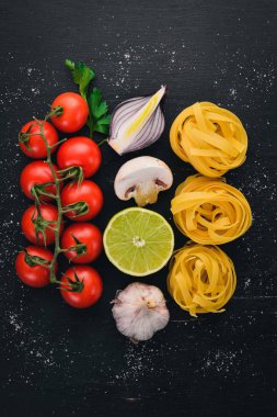 Makarna tagliatelle, ahşap bir zemin üzerine sebzeli fettuccine kuru. Geleneksel İtalyan mutfağı. Üstten Görünüm. Kopya alanı.