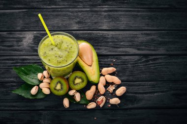 Kivi güler yüzlü ve keten tohumu ve fındık ile avokado. Ahşap bir arka plan üzerinde. Üstten Görünüm. Metniniz için boş alan.