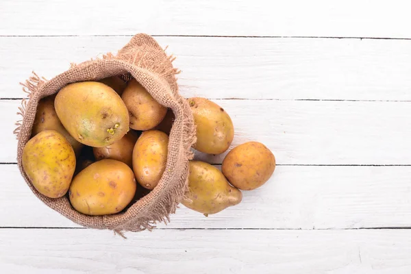 Raw potatoes. On a white background. Cooking. Free space for text. Top view.