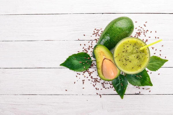 Avocado smoothie and flax seeds and nuts. On a wooden background. Free space for text. Top view.