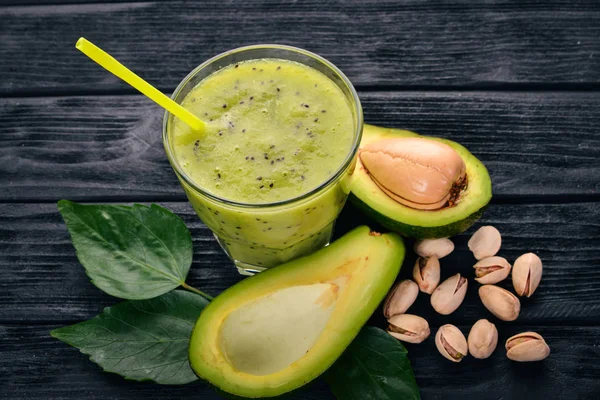 Avocado smoothie and flax seeds and nuts. On a wooden background. Free space for text. Top view.