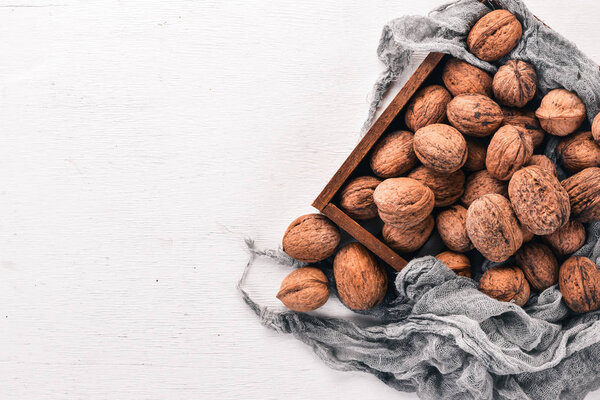Walnut. In a box on a wooden background. Top view. Copy space.