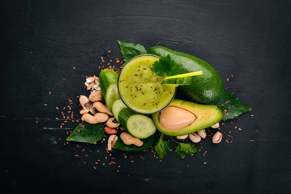 Smoothie with avocado and cucumber with flaxseed and nuts. On a wooden background. Top view. Free space for your text.