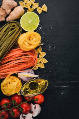 Bir makarna, erişte, makarna, tagliatelle, fettuccine, dizi Farfalle. İtalyan yemek, taze sebze ve baharat. Siyah ahşap arka plan üzerinde. Üstten Görünüm. Kopya alanı.