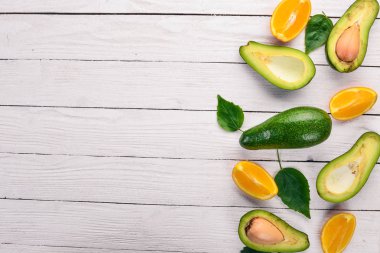 Portakal ve ahşap arka plan üzerinde avokado. Üstten Görünüm. Metniniz için boş alan.