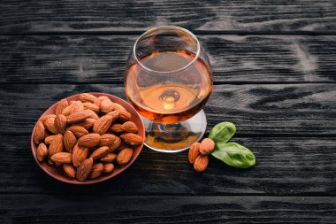 Amaretto badem likörü. Badem ahşap arka plan üzerinde. İtalyan içki üstten görünüm. Metin için boş alan.