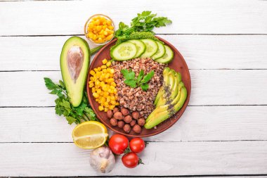 Sağlıklı gıda. Karabuğday, avokado, salatalık, Mısır ve fındık. Ahşap bir arka plan üzerinde. Üstten Görünüm. Metniniz için boş alan.