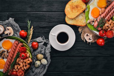 Tam İngiliz kahvaltısı kızarmış yumurta, sosis, fasulye, tost ve kahve kopya alan arka plan üzerinde. Siyah bir ahşap arka plan üzerinde.