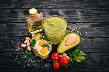 Avokado, yumurta, domates ve antep fıstığı ile sandviç. Kivi suyu. Ahşap bir arka plan üzerinde. Üstten Görünüm. Metniniz için boş alan.