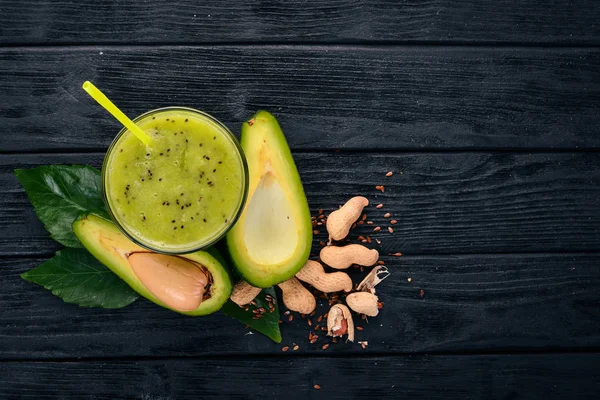 Avocado smoothie and flax seeds and nuts. On a wooden background. Free space for text. Top view.