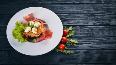 Jambon, bıldırcın yumurtası, Kuru erik ve plaka üzerinde taze sebze salatası. Ahşap bir arka plan üzerinde. Üstten Görünüm. Metin için boş alan.