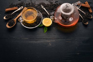 Baharat ve otlar ile cam fincan çay. Siyah ahşap arka plan üzerinde. Üstten Görünüm. Kopya alanı.