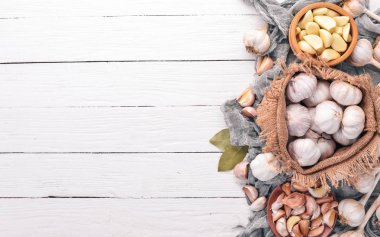 Sarımsak. Beyaz ahşap zemin üzerinde taze sarımsak kümesi. Üstten Görünüm. Kopya alanı.