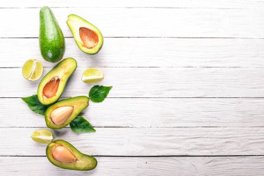 Avokado ve kireç ahşap arka plan üzerinde. Üstten Görünüm. Metniniz için boş alan.
