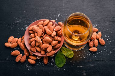 Amaretto badem likörü. Badem ahşap arka plan üzerinde. İtalyan içki üstten görünüm. Metin için boş alan.
