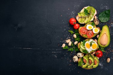 Avokado sandviç, kiraz domates ve bıldırcın yumurtası ve chia tohum kümesi. Ahşap bir arka plan üzerinde. Üstten Görünüm. Metniniz için boş alan.