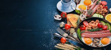 İngiliz kahvaltısı. Kızarmış yumurta, sosis, pastırma, fasulye, tost, domates, kahve fincanı taştan masada. Metin alanı olan Üstten Görünüm