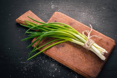 Ahşap arka plan üzerinde taze yeşil soğan. Üstten Görünüm. Metniniz için boş alan.