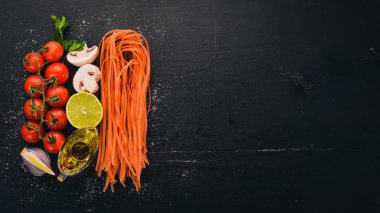 Kırmızı makarna domates ile. Geleneksel İtalyan mutfağı. Ahşap bir arka plan üzerinde. Üstten Görünüm. Kopya alanı.