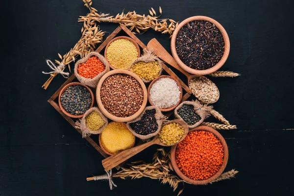 A set of cereals and grains in a wooden basket on a wooden background. Top view. Copy space.