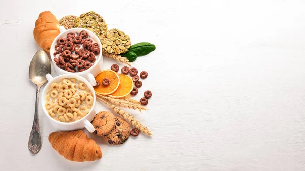 Fitness breakfast, muesli, milk, fruits, nuts and seeds, on a wooden surface. Top view. Free space for text.