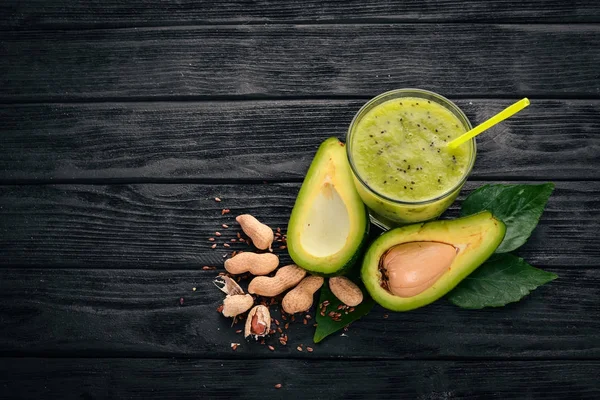 Avocado smoothie and flax seeds and nuts. On a wooden background. Free space for text. Top view.