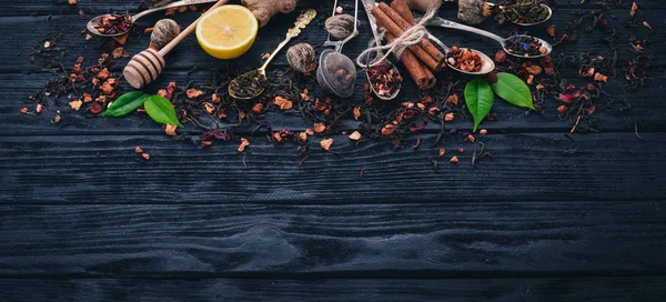 Assortment of dry teas and fragrant herbs and spices. On a wooden background. Top view. Copy space.