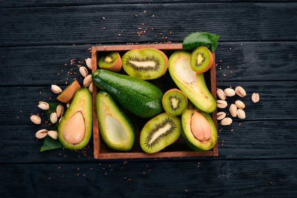 Kiwi Avocado Een Houten Mand Een Houten Achtergrond Bovenaanzicht Vrije — Stockfoto