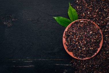 Siyah kuru pirinç. Ahşap bir arka plan üzerinde. Üstten Görünüm. Kopya alanı.