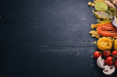 Bir makarna, erişte, makarna, tagliatelle, fettuccine, dizi Farfalle. İtalyan yemek, taze sebze ve baharat. Siyah ahşap arka plan üzerinde. Üstten Görünüm. Kopya alanı.