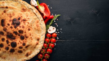 Pizza volkan. Gorgonzola peyniri, domates, taze sebze ve baharat. Ahşap bir arka plan üzerinde. Metniniz için boş alan. Üstten Görünüm.