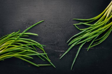 Ahşap arka plan üzerinde taze yeşil soğan. Üstten Görünüm. Metniniz için boş alan.