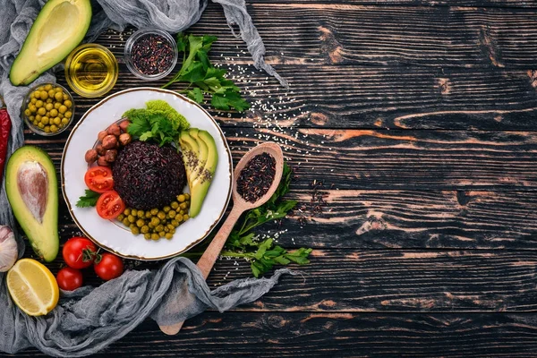 健康食品 アボカド チェリー トマト グリーン ピースとヘーゼル ナッツ 木製の背景 平面図です テキストの無料スペース — ストック写真