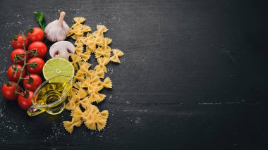 Ahşap arka plan üzerinde sebzeli makarna Farfalle kuru. Üstten Görünüm. Kopya alanı.