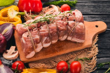 Taze sebze ve biberiye ve baharat siyah ahşap zemin ile çiğ et sığır filetosu. Üstten Görünüm. Metin için boş alan.