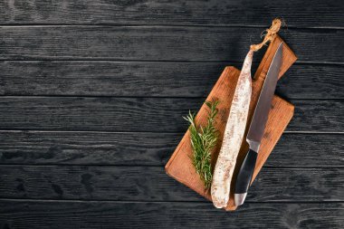 Fuet, salam ve Rosemary. Geleneksel İspanyol sosis. Siyah ahşap arka plan üzerinde. Üstten Görünüm.
