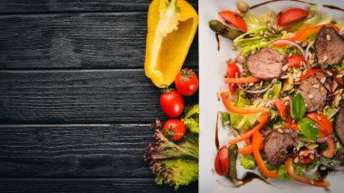 Dana salata, marul ve plaka üzerinde taze sebze. Ahşap bir arka plan üzerinde. Üstten Görünüm. Metin için boş alan.