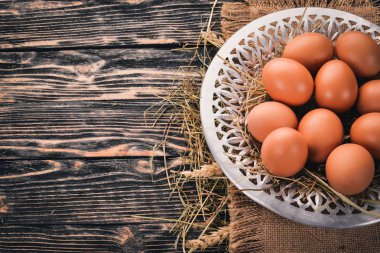 Metal bir plaka üzerinde tavuk çiğ yumurta. Ahşap bir arka plan üzerinde. Üstten Görünüm. Kopya alanı.