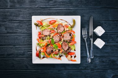 Dana salata, marul ve plaka üzerinde taze sebze. Ahşap bir arka plan üzerinde. Üstten Görünüm. Metin için boş alan.