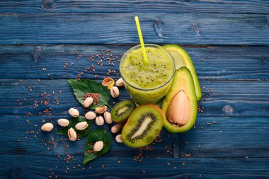 Kivi güler yüzlü ve keten tohumu ve fındık ile avokado. Ahşap bir arka plan üzerinde. Üstten Görünüm. Metniniz için boş alan.