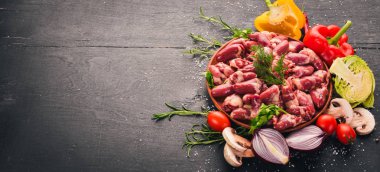 Çiğ tavuk kupa rosemary ile yemek pişirmek için hazır plaka üzerinde ve üzerinde baharat siyah ahşap arka plan. Üstten Görünüm. Metin için boş alan.